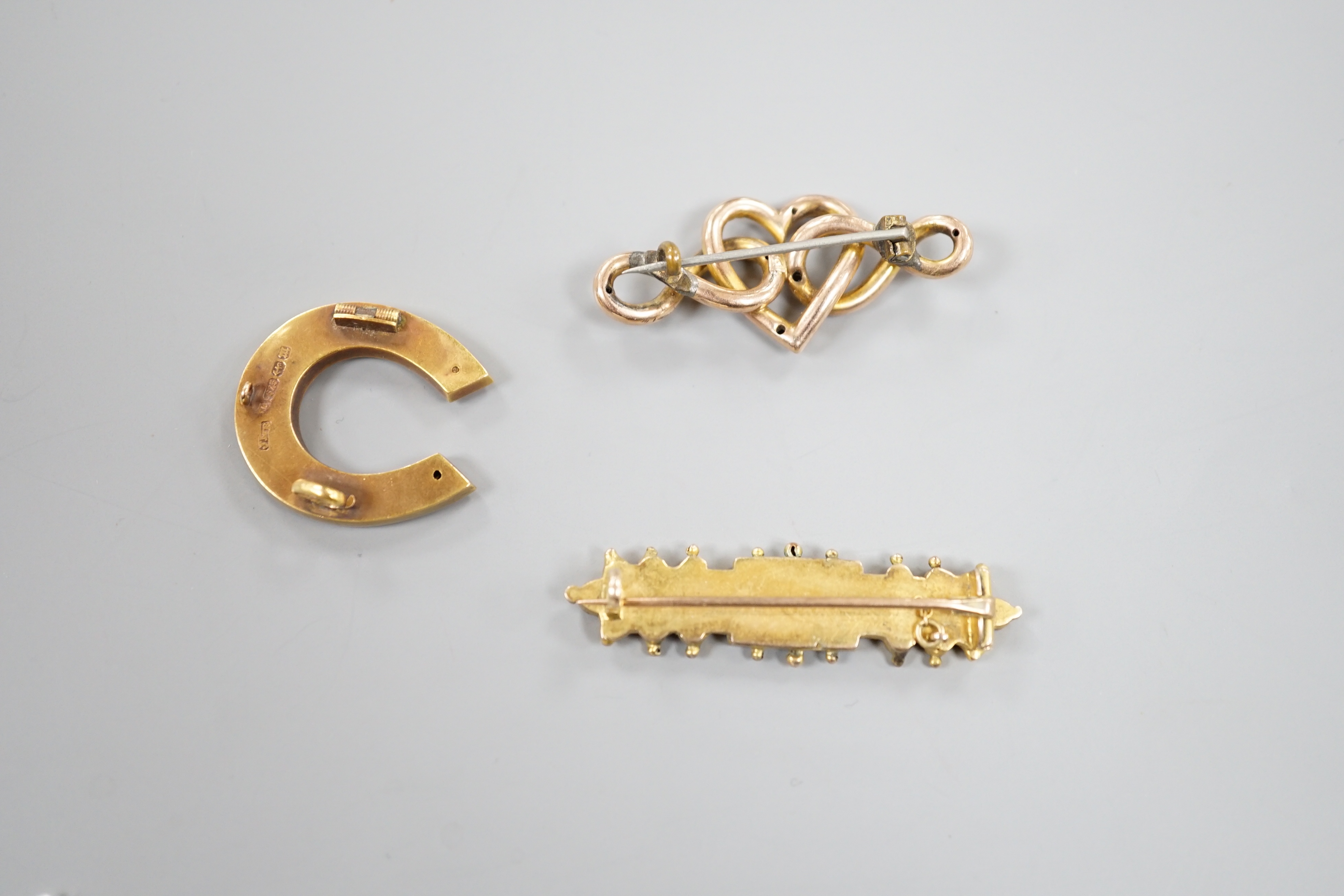 A late Victorian 15ct gold, seed pearl and gem set horseshoe brooch(a.f.), 24mm, 3.6 grams and tow later brooches, one 9ct, gross 8 grams.